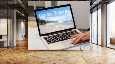 GO TO TRAVEL キャンペーン　　Go Toキャンペーン
旅行のオンライン予約検索のイメージ　ノートパソコンで旅行の予約検索の画面を見せている女性の手 Wall mural